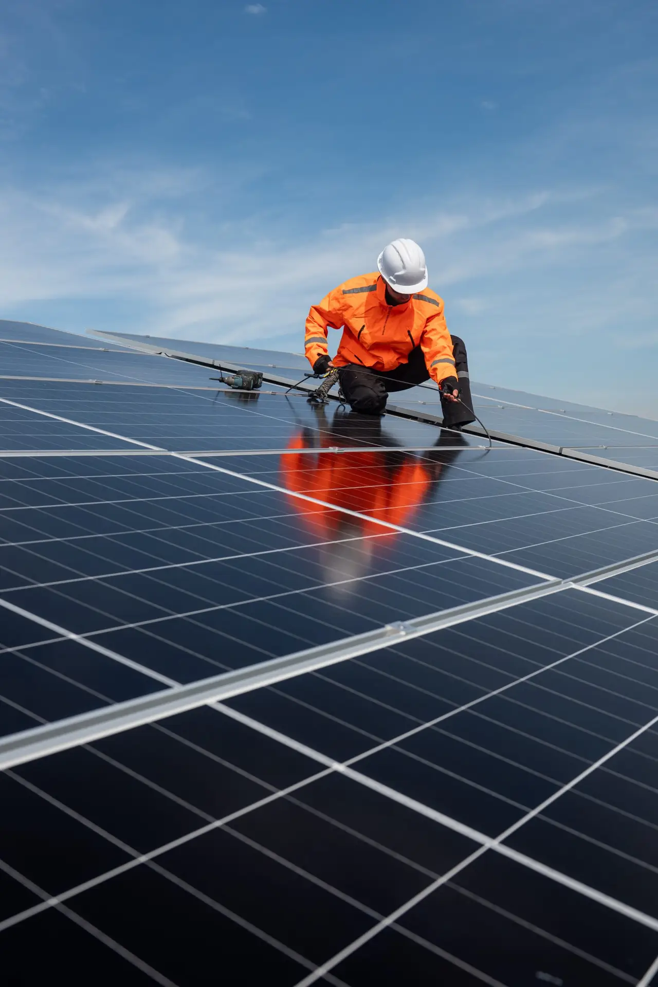 technician,installing,solar,panels,on,factory,roof,for,green,energy.